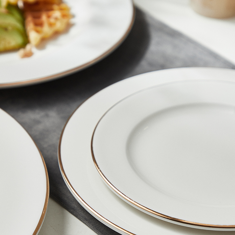 White porcelain dinner plate with gold rim