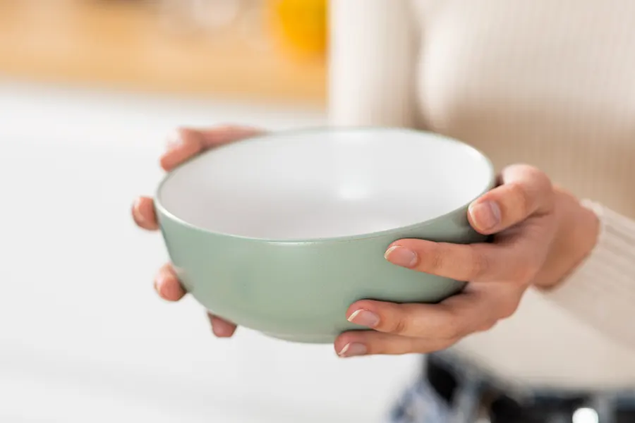 a people holding a large ceramic bowl