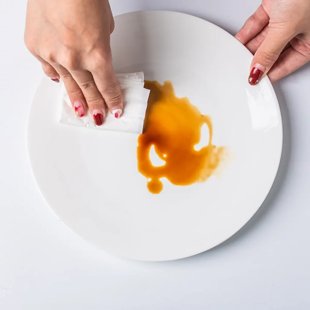 a people wiping the white ceramic plates